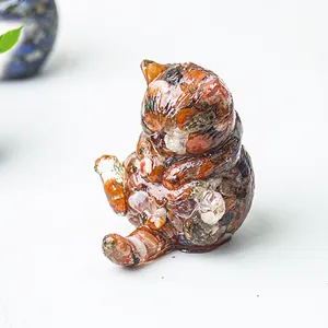 Dettaglio di statuetta a forma di gatto in resina con pietre naturali colorate
