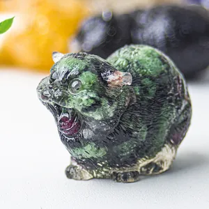 Macro detail of cat statue featuring natural green crystal stone and smooth resin finish