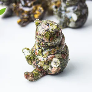 Vista macro di una statuetta di gatto seduto in pietra verde e resina lucida