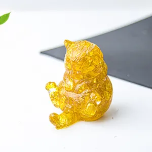 Dettaglio macro di statuetta a forma di gatto in resina trasparente e cristalli gialli