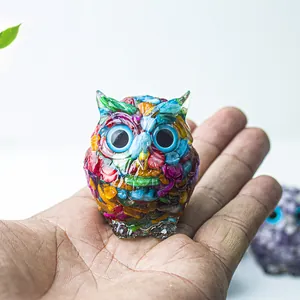 Figurine chouette en pierres de cristal colorées pour déco, tenue en main sur fond blanc