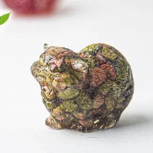 Macro shot of natural unakite crystal cat figurine with green and pink stone textures