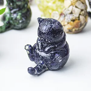 Dettaglio di una statuetta di gatto in resina blu con glitter e pietre di cristallo