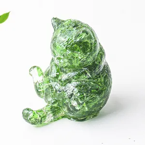 Dettaglio macro di una statuetta di gatto in cristallo verde con crepe di ghiaccio
