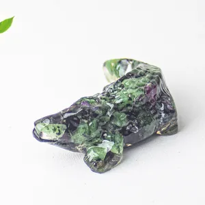 Close-up of crocodile resin sculpture with green and purple crystal stone texture