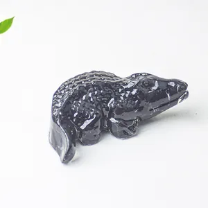 Detailed close-up of a glossy black resin crocodile figurine with realistic scale textures