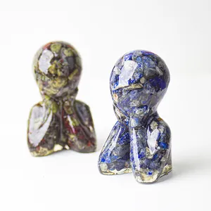 Macro detail of resin figurines with blue and green natural crystals in thinking pose