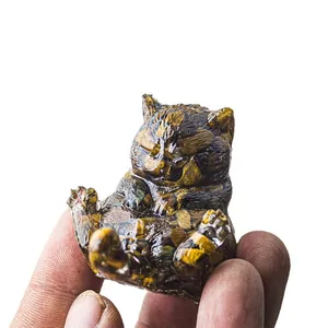 Mini statuetta di gatto in resina occhio di tigre tenuta in mano per mostrare la misura
