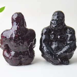 Macro view of gorilla resin statues in black and deep red with polished stone texture