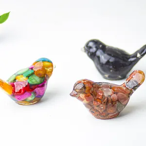 Close-up of bird statues made with resin and natural crystal stones for home decor