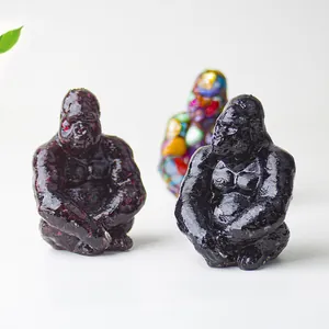 Detail of sitting gorilla resin statues featuring red and black glossy crystal finishes