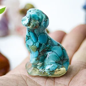 Close-up of sitting puppy statue made of turquoise resin and natural crystals in hand