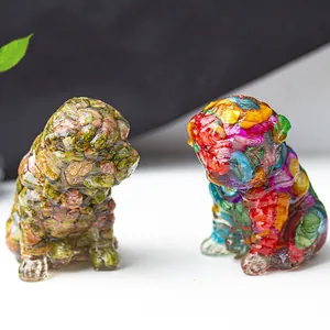 Detail of resin shar-pei statues filled with colorful stones on a white surface