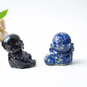 Detail of two monk figurines made of black obsidian and blue lapis lazuli resin crystals