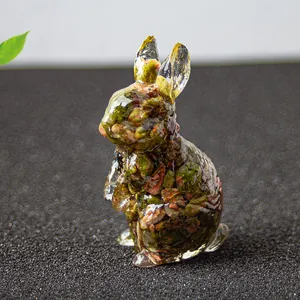Vue macro d'une figurine de lapin en résine avec cristaux naturels et pierres vertes