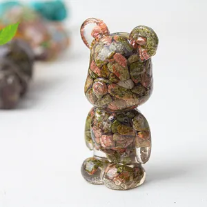 Close-up of bear figurine with natural green and red crushed stones in clear resin