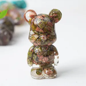 Macro detail of transparent resin bear ornament filled with natural colorful crystal stones