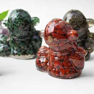 Detailed macro shot of a resin figurine filled with red natural crystal chips on a desk
