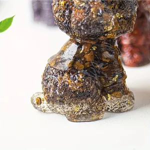 Detailed macro view of resin bear statue with tiger eye stones and gold foil accents