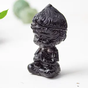 Close-up of a black resin Monkey King statue with polished finish in a zen prayer pose