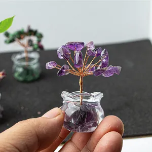 Miniature amethyst crystal money tree detail in glass jar held by hand for scale