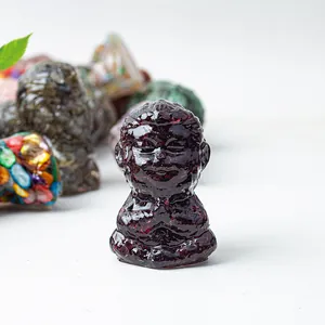 Macro shot of dark purple resin meditation monkey statue with crystal stone textures
