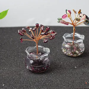 Macro shot of two mini crystal money trees with glass bases and colorful gemstones