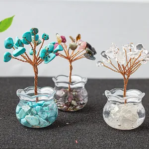 Three handmade crystal trees with amethyst and citrine stones in glass pots on a dark surface