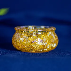 Détail macro d'un bol en cristal de résine jaune sur fond de velours bleu décoratif