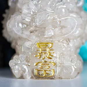 Macro shot of a clear crystal lucky lion statue with a gold Baofu prosperity inscription