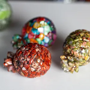 Close-up of resin pomegranate statues with colorful natural crystal stone fillings