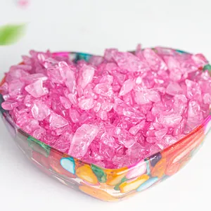 Macro view of polished pink crystal gravel in a shell-textured heart-shaped glass bowl