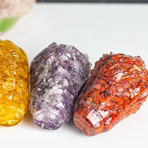 Three conical resin statues filled with natural crystal stones on white surface
