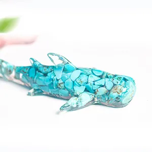 Makro-Detail von Haifisch-Resin-Ornament gefüllt mit Türkis-Natursteinen auf Weiß