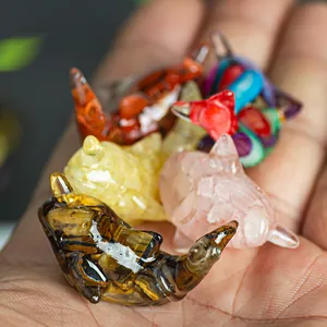 Mini resin whale figurines filled with natural crystal stones held in a person's palm
