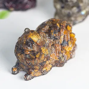 Macro shot of Pomeranian resin statue with detailed brown tiger eye crystal texture