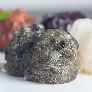 Macro detail of hand-carved labradorite animal sculpture with vibrant blue-green iridescence