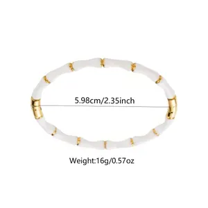 Détail d'un bracelet style bambou avec résine blanche et perles en métal doré