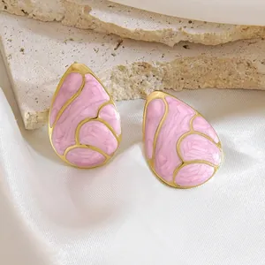 Pink and gold waterdrop earrings with marble texture on silk and stone background