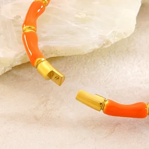Makroaufnahme des vergoldeten Bambus-Armbands aus Edelstahl mit orangem Emaille-Detail