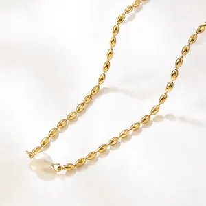 Vue détaillée d'un collier de perles ovales dorées avec un pendentif perle baroque blanche