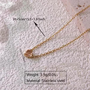 Detail of pink heart birthstone pendant on gold stainless steel chain necklace