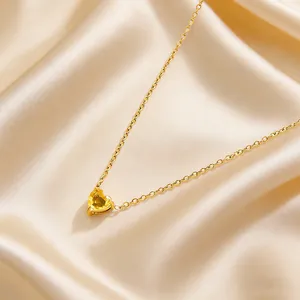 Close-up of yellow heart-shaped birthstone necklace on premium champagne silk fabric