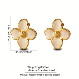 Detail view of flower-shaped stainless steel earrings with white enamel and golden plating