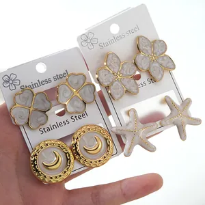 Set of four gold-plated stainless steel earrings with moon, flower, and starfish charms
