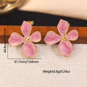 Macro shot of pink enamel flower earrings with gold edges and detailed dimensions