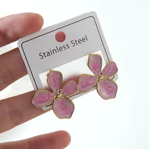 Detailed close-up of pink flower petal earrings with gold finish on stainless steel