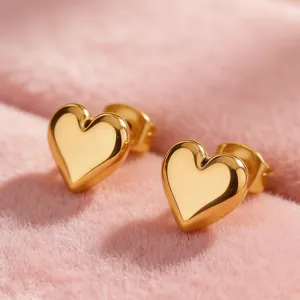 Γυαλισμένα χρυσά σκουλαρίκια καρδιά 18k σε κομψό ροζ βελούδινο φόντο