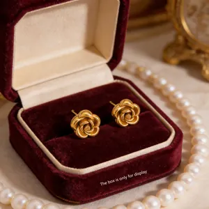 Vintage gold rose stud earrings with matte finish in a red jewelry box setting