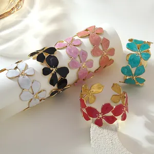 Dettaglio di bracciali a fiori in smalto colorato con montatura in acciaio inossidabile oro
